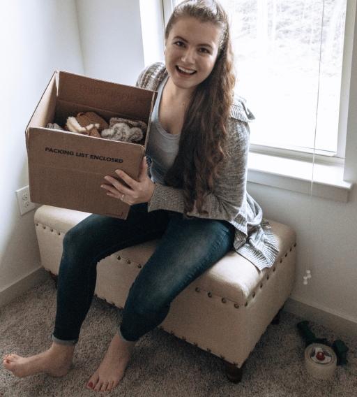 Jaclyn, maker at Raspberriez Handmade baby shoes, smiles with a box of baby booties.